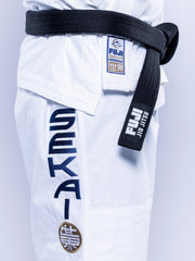 Close-up of a person wearing the SEKAI 3.0 BJJ Gi White Navy with blue Sekai lettering, a black belt, and Fuji brand patches on both the gi and the belt.